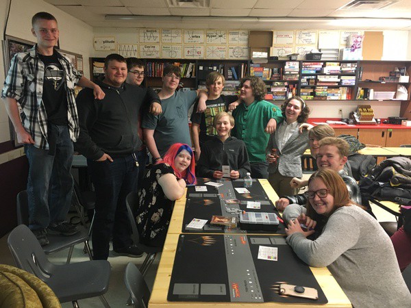 A dozen students posing with games.